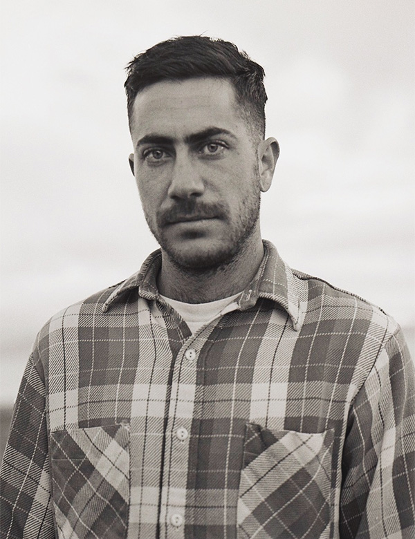 A black and white headshot of the artist, Nicholas Aiden